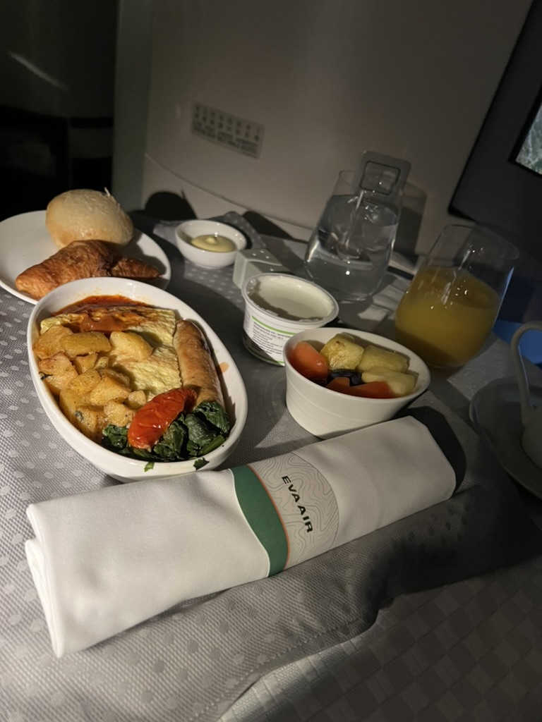 Frukost serverad på duk i Business Class med varmrätt, bröd och juice