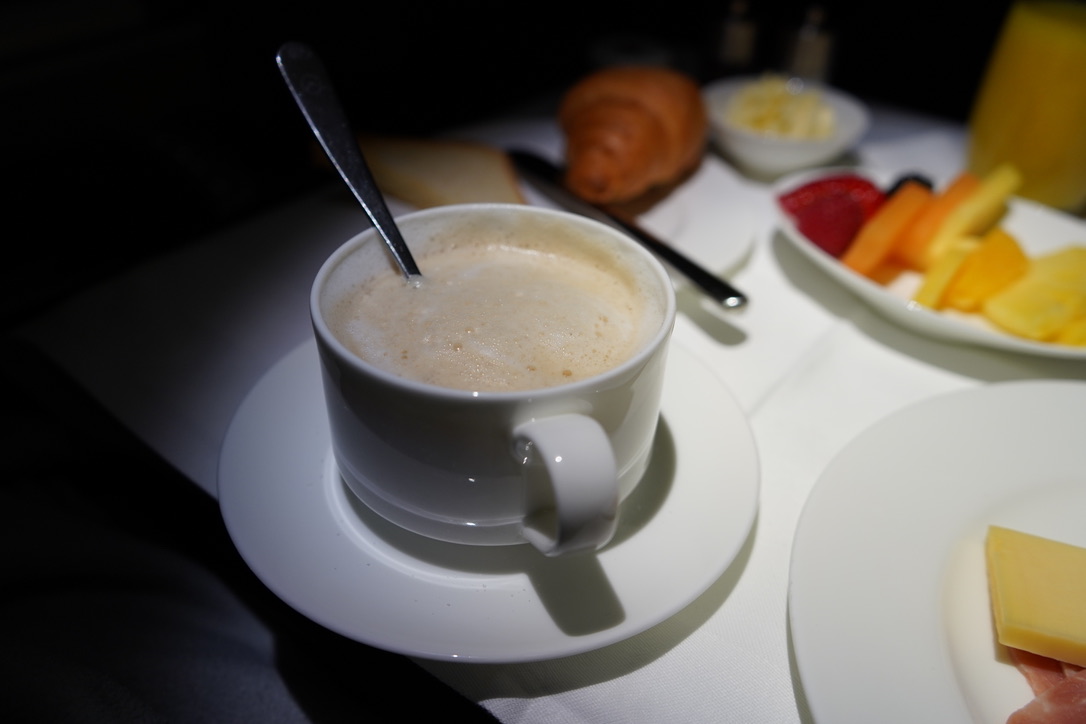 Cappuccino, croissant och frukttallrik till frukost ombord