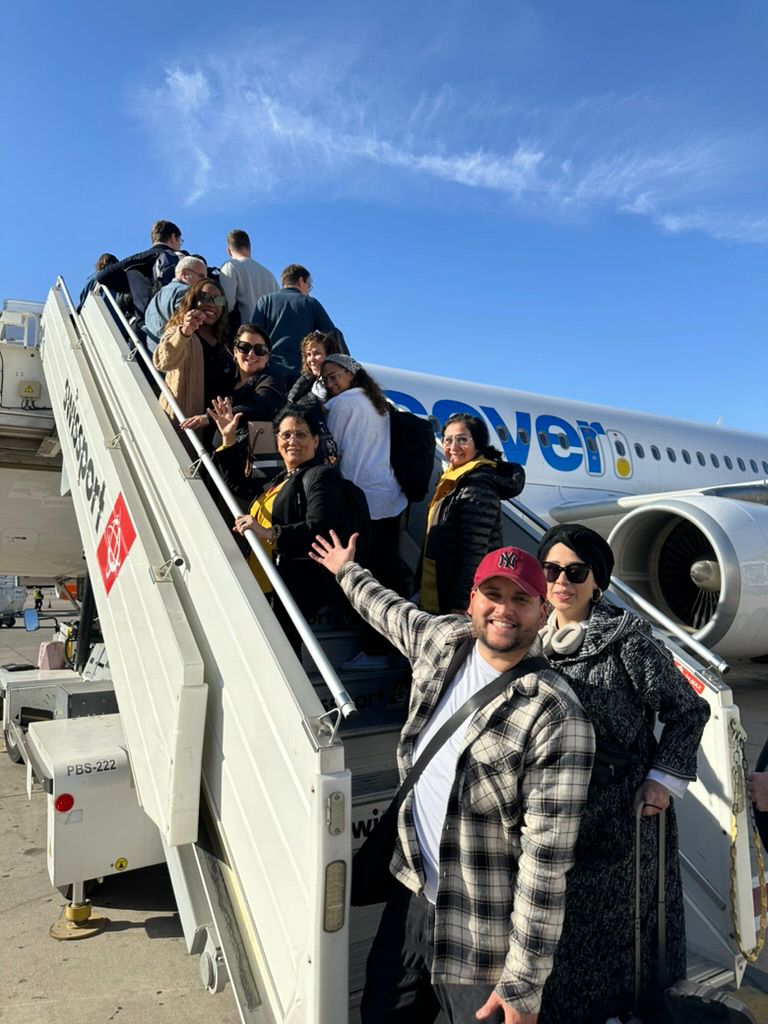Resenärer i VCY Travels gemenskap går ombord på planet genom trappan inför en grupresa
