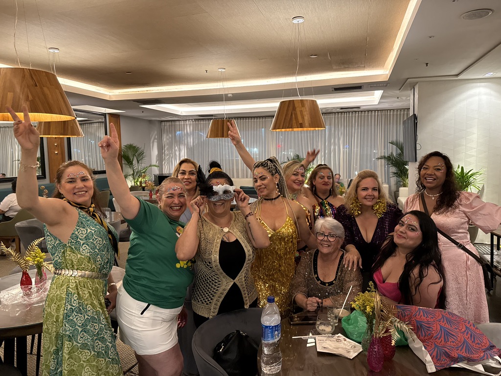 Resenärer i karnevalskläder och glitter firar tillsammans på restaurang under gruppresan