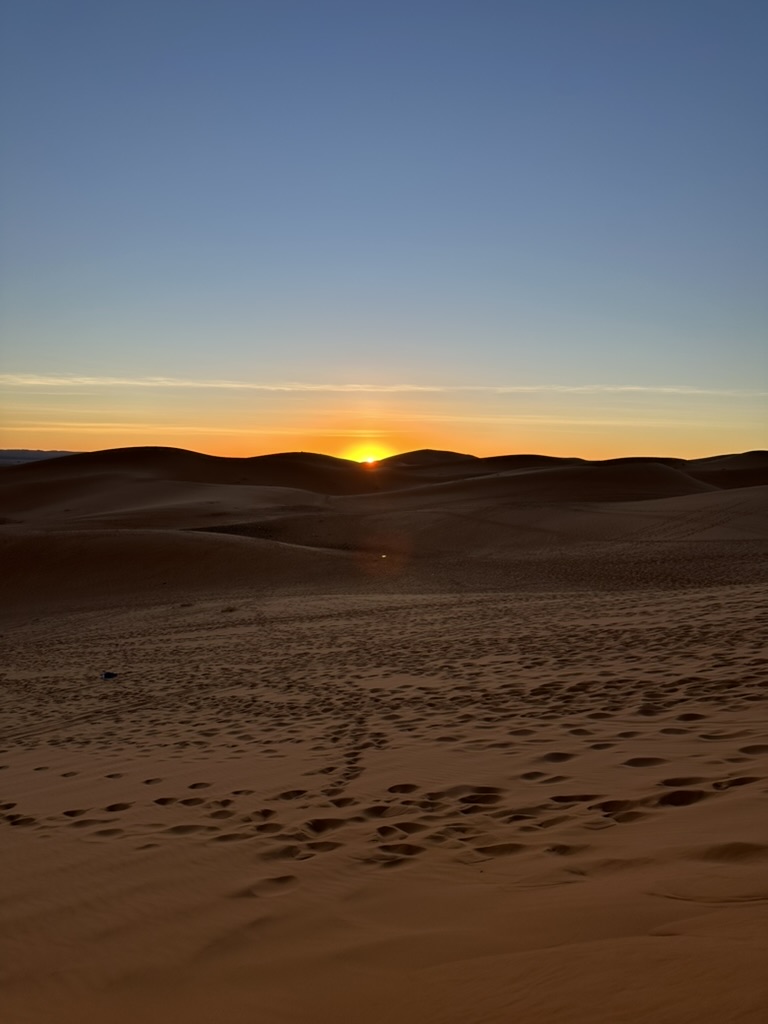 Solen vid horisonten bakom öknens sanddyner