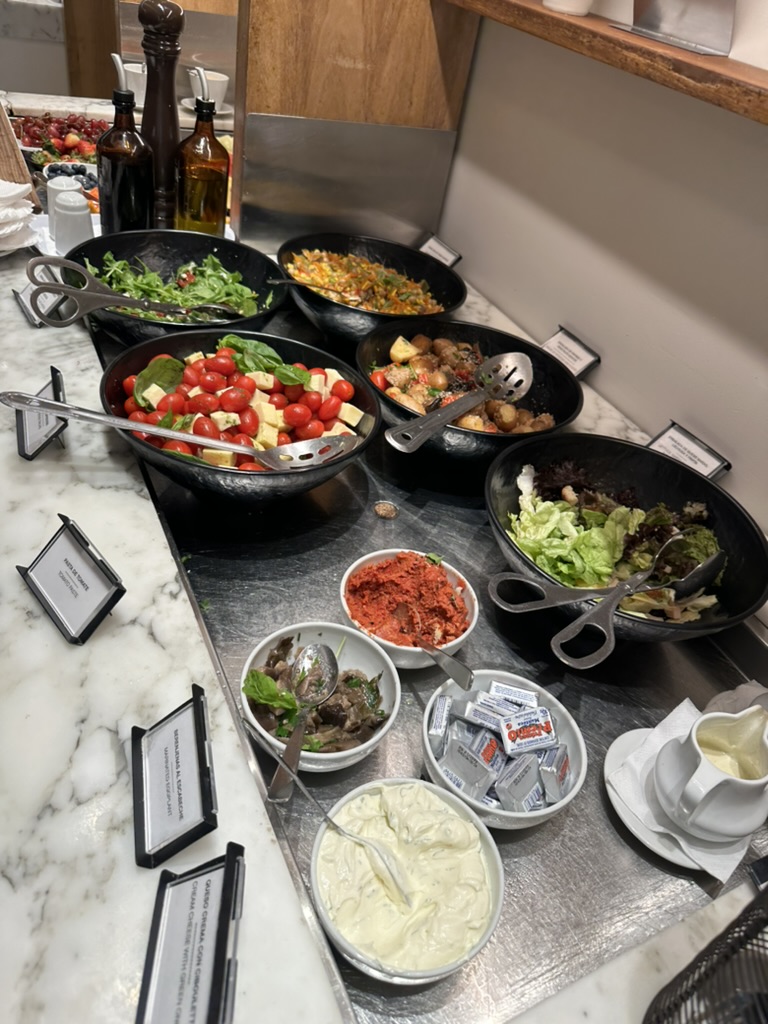 Buffé med salader, varmrätter och tillbehör i flygplatslounge